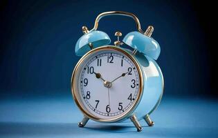 Classic blue alarm clock on a blue background showcasing timeless design and functionality photo