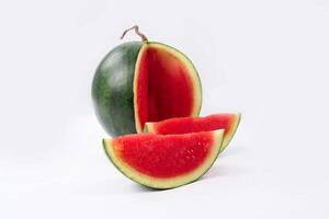 Whole watermelon and seeded slices seen front and top on a white background. Watermelon slices are red, seedy and juicy. photo
