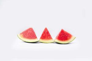 Whole watermelon and seeded slices seen front and top on a white background. Watermelon slices are red, seedy and juicy. photo