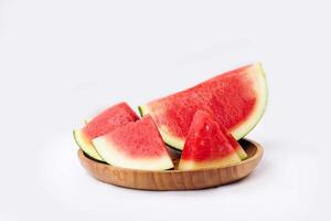 Whole watermelon and seeded slices seen front and top on a white background. Watermelon slices are red, seedy and juicy. photo