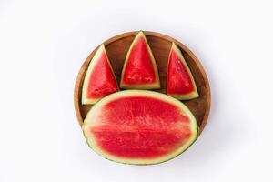 Whole watermelon and seeded slices seen front and top on a white background. Watermelon slices are red, seedy and juicy. photo