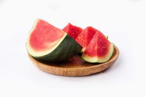 Whole watermelon and seeded slices seen front and top on a white background. Watermelon slices are red, seedy and juicy. photo
