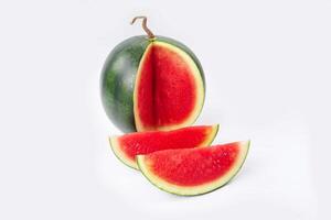 Whole watermelon and seeded slices seen front and top on a white background. Watermelon slices are red, seedy and juicy. photo