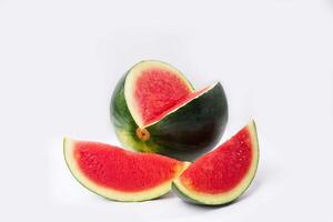 Whole watermelon and seeded slices seen front and top on a white background. Watermelon slices are red, seedy and juicy. photo