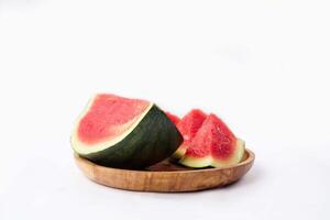 Whole watermelon and seeded slices seen front and top on a white background. Watermelon slices are red, seedy and juicy. photo