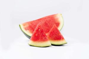 Whole watermelon and seeded slices seen front and top on a white background. Watermelon slices are red, seedy and juicy. photo
