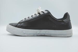 shoe sneaker on white background, close up of sneaker on white background, old black generic sneakers on white background. photo