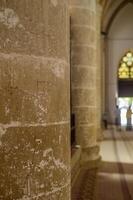 Exploring ancient stone columns inside a historic cathedral on a sunny afternoon photo