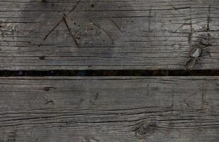 Weathered wooden planks with gaps showing signs of age and wear in a rustic setting photo