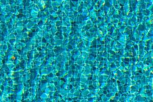 The Tranquil Dance of Sunlight Over a Refreshing Swimming Pool Surface on a Bright Summer Afternoon photo