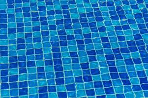 A Captivating View of Shimmering Blue Tiles Reflecting Sunlight in a Tranquil Swimming Pool on a Sunny Day photo