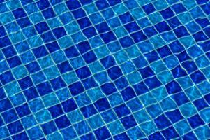 Rippling azure water reflecting sunlight over a tiled pool during a summer afternoon photo