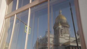 Reflection in window of ancient cathedral. Action. Ancient cathedral with dome is reflected in window of modern building. Reflection of cathedral in window of building on sunny day video