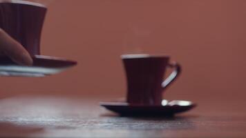 Close up of woman hands putting small cup of coffee on the table. Concept. Concept of morning routine. video