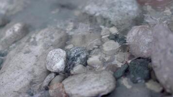 Close-up of gray stones with clear water. Stock footage. Stones in clear water with ripples on surface. Stones in clean spring water source video