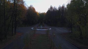 A quiet evening empty park. Clip. Helicopter view of the resting area with benches, roads and a fountain. video