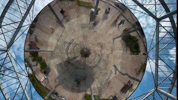 A large mirror at the top. Clip. The mirror at the top shows people walking in the park and the blue sky. video