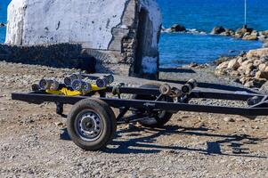 A rugged trailer ready for adventure by the serene coastal waters at midday photo