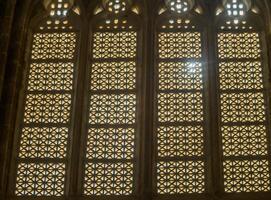 Intricate geometric patterns of stained glass windows illuminating an ancient cathedral during golden hour photo
