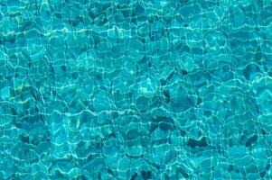 The Shimmering Turquoise Surface of a Tranquil Pool Reflecting Sunlight and Creating Mesmerizing Patterns photo