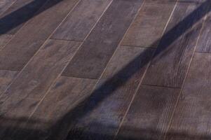 Warm Sunlight Filters Through, Casting Intricate Shadows on a Rustic Wooden Floor in a Tranquil Indoor Space photo