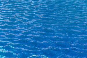 Rippling azure waters reflecting sunlight on a tranquil summer afternoon by the beach photo