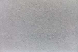An abstract view of a textured gray wall showcasing subtle variations in color and tone under soft natural light photo
