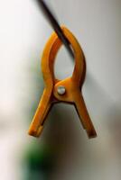 A yellow cloth pin hanging from a string photo