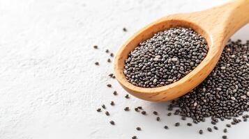 Chia seeds spilling from a wooden spoon on a clean white background. photo