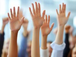 Group of diverse hands raised in a collaborative or participatory event, symbolizing engagement and enthusiasm in a dynamic setting. photo