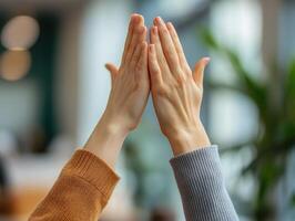 Two hands meeting in a gesture of connection, symbolizing unity and collaboration in a bright and modern environment. photo