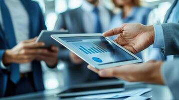 Business professionals collaborating with digital tablet showcasing data graphics in a corporate environment, demonstrating teamwork and technology integration. photo