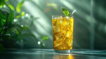 A refreshing glass of cold iced tea with ice cubes and a sprig of mint, set against a blurred green background that evokes a calm and soothing atmosphere. photo