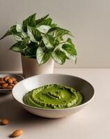 Pesto with almonds and basil on a white table photo