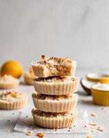 A stack of lemon coconut bars with a bowl of lemon curd photo
