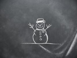 A snowman drawn on a chalkboard with a smile photo