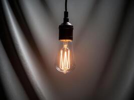 A light bulb is shown in front of a dark background photo