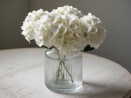 A vase with white flowers sitting on a table photo
