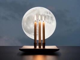 Candle with three candles on a table in front of a full moon photo