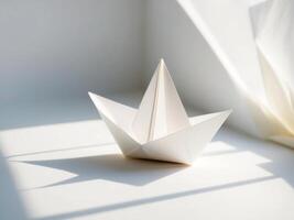 A paper boat sitting on a table in front of a window photo
