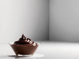 Chocolate pudding in a glass bowl on a white table photo
