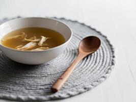 Chicken soup in a bowl with a wooden spoon photo