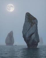 Moonrise over the rock formations in the ocean photo