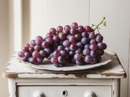 A bunch of grapes on a plate on a table photo