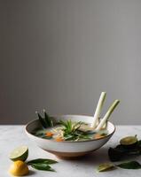 A bowl of soup with lemons and vegetables photo