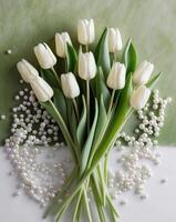White tulips on a green background with pearls photo
