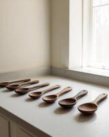 Six wooden spoons lined up on a counter photo