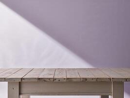 A wooden table with a purple wall behind it photo