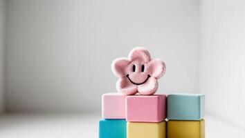 A pink flower on top of colorful blocks photo