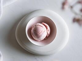 A bowl of ice cream sits on a white surface photo